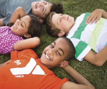 Kids lying in grass smiling