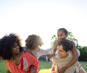 Parents gives their kids piggyback rides